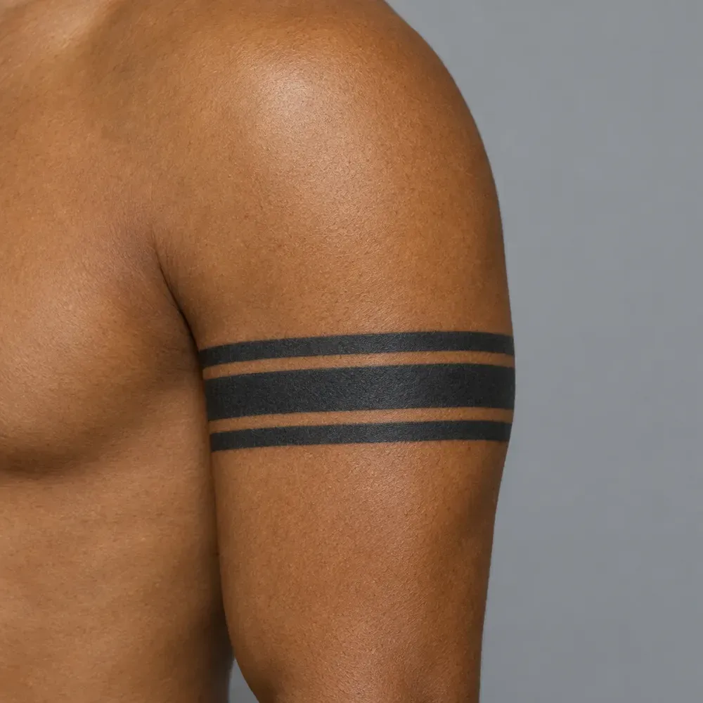 Three solid black stripes tattooed around the bicep of warm brown skin.