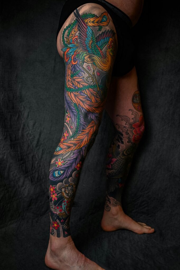 Close-up of a vibrant tattoo sleeve on a leg, showcasing detailed colorful design.