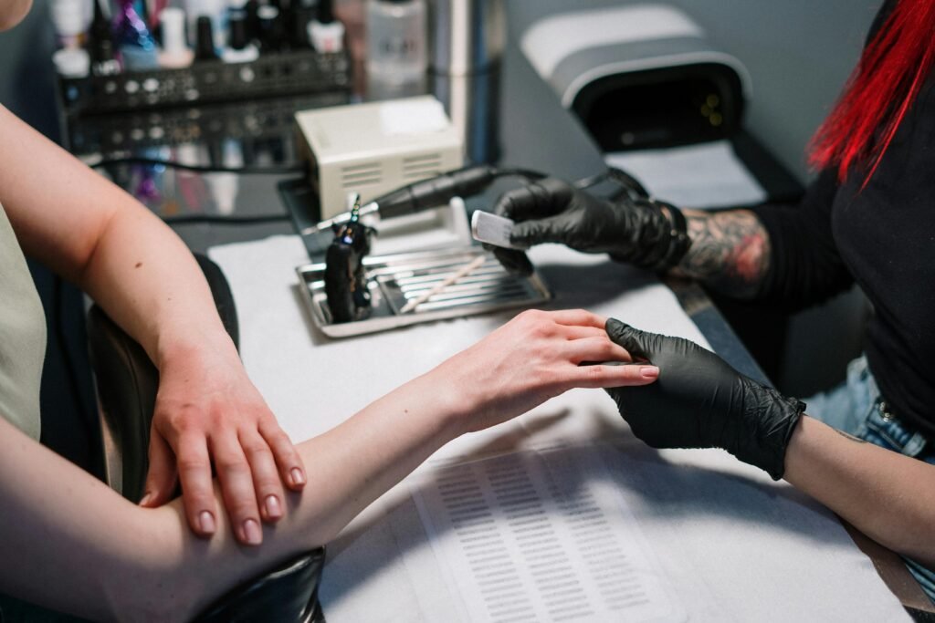 Close-up of a manicure process with black gloves and nail polish in a nail salon.